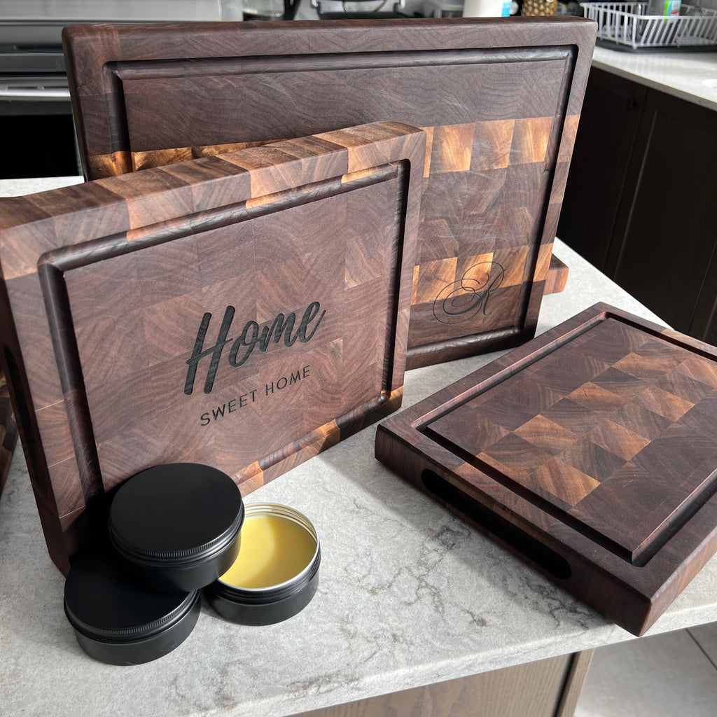 Set of wooden cutting boards with 'Home Sweet Home' engraving on a kitchen counter.